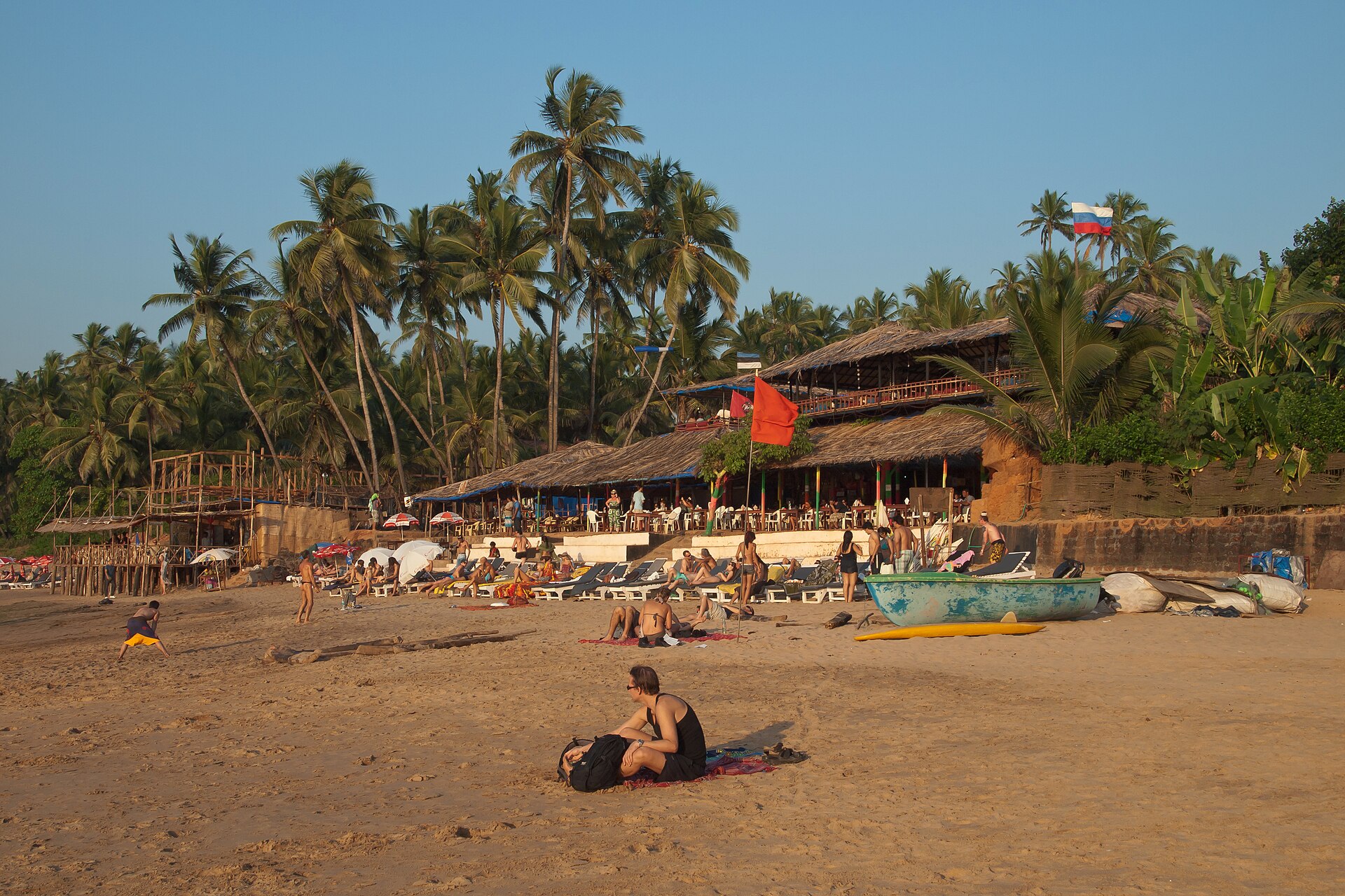 Rocky shoreline and legendary beach shacks facing breaking waves at Anjuna Beach in North Goa