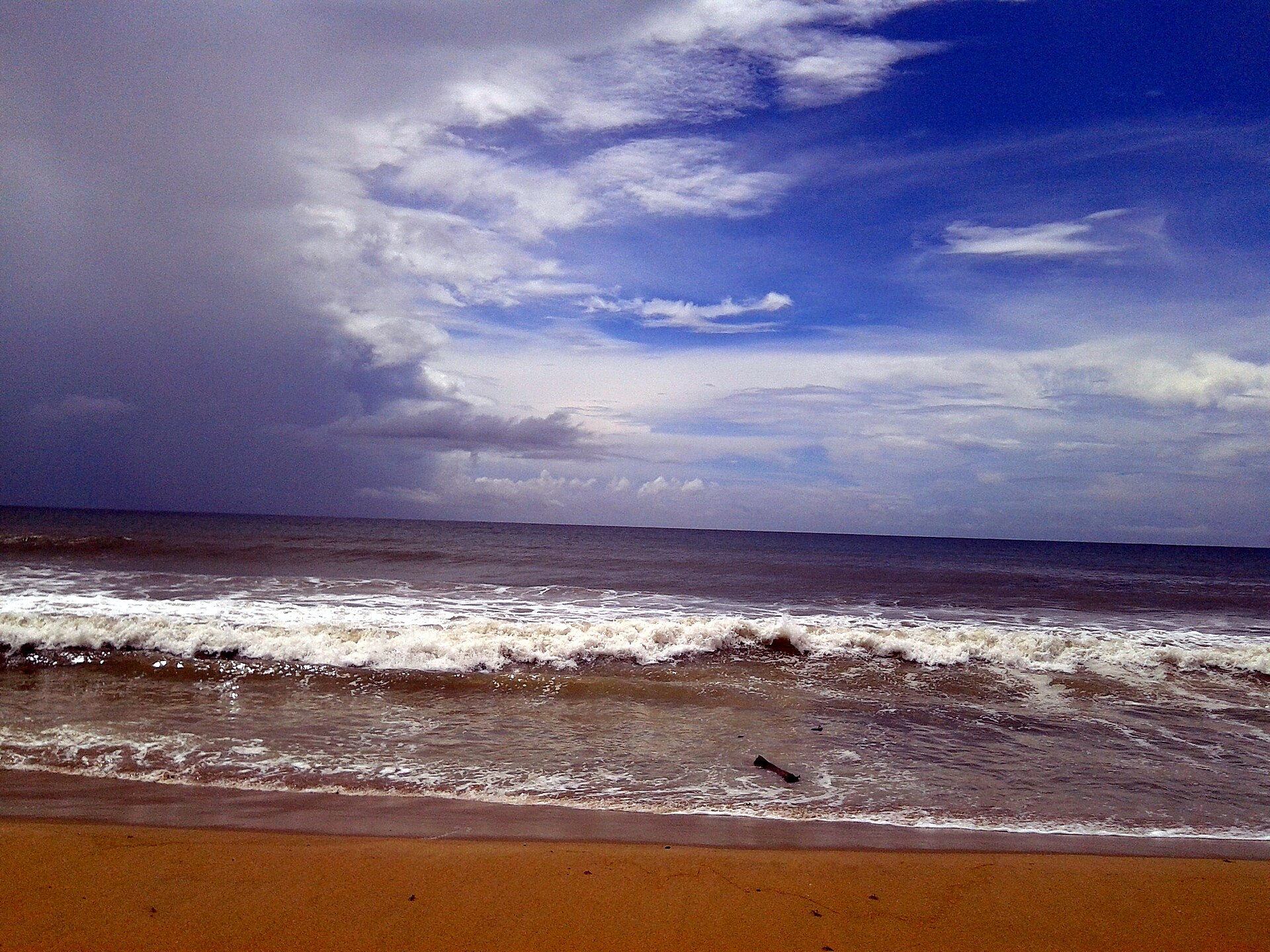 Broad sandy Coromandel shoreline and rolling Bay of Bengal surf at Auroville Beach in Puducherry