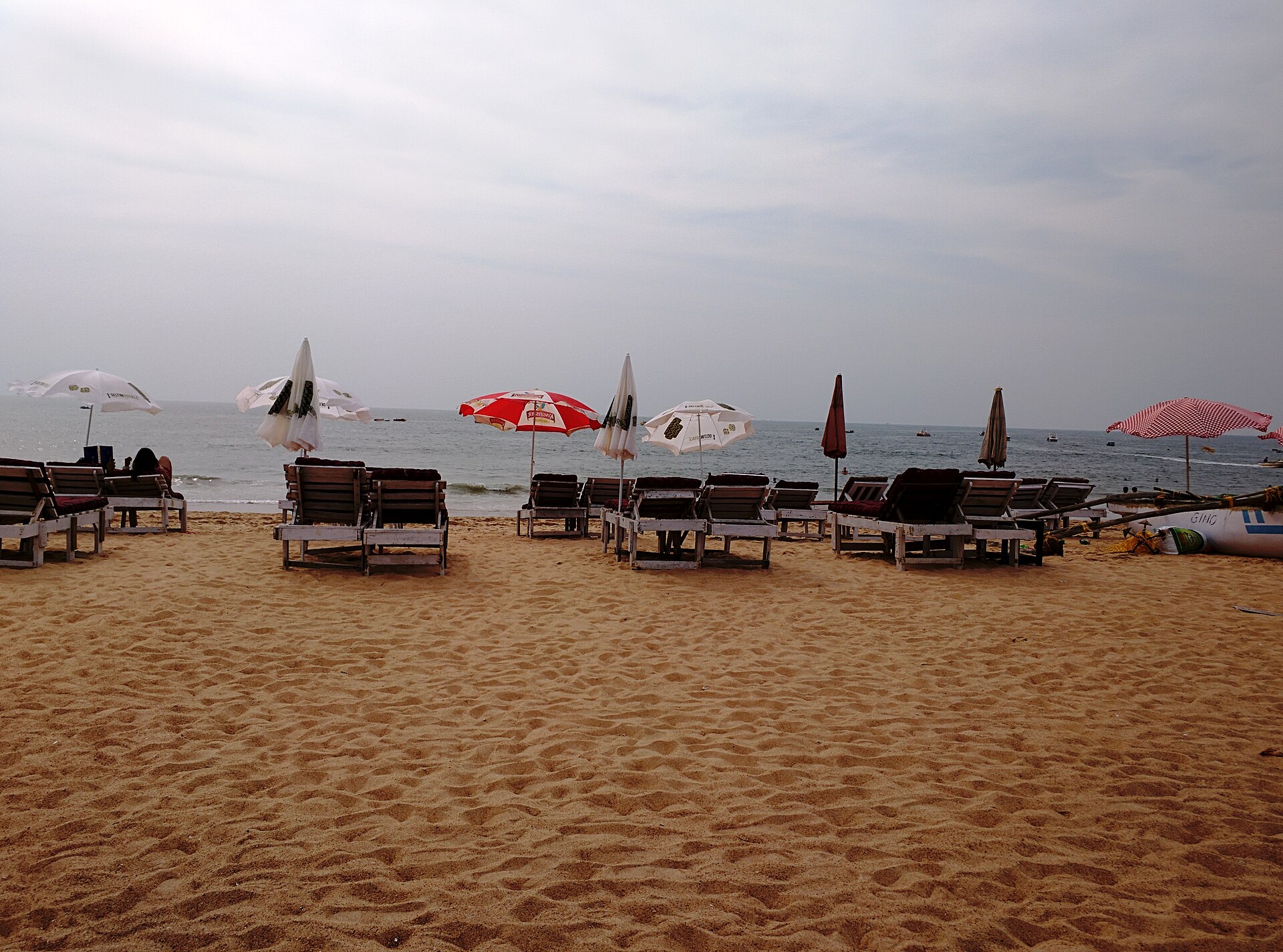 Expansive golden sands, green dunes, and blue Arabian Sea at Candolim Beach in North Goa