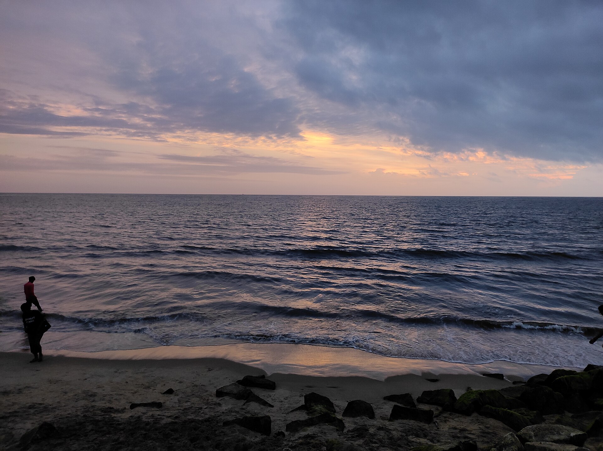 Broad golden sandy swimming beach and gently breaking waves at Cherai Beach on Vypin Island in Kochi, Kerala