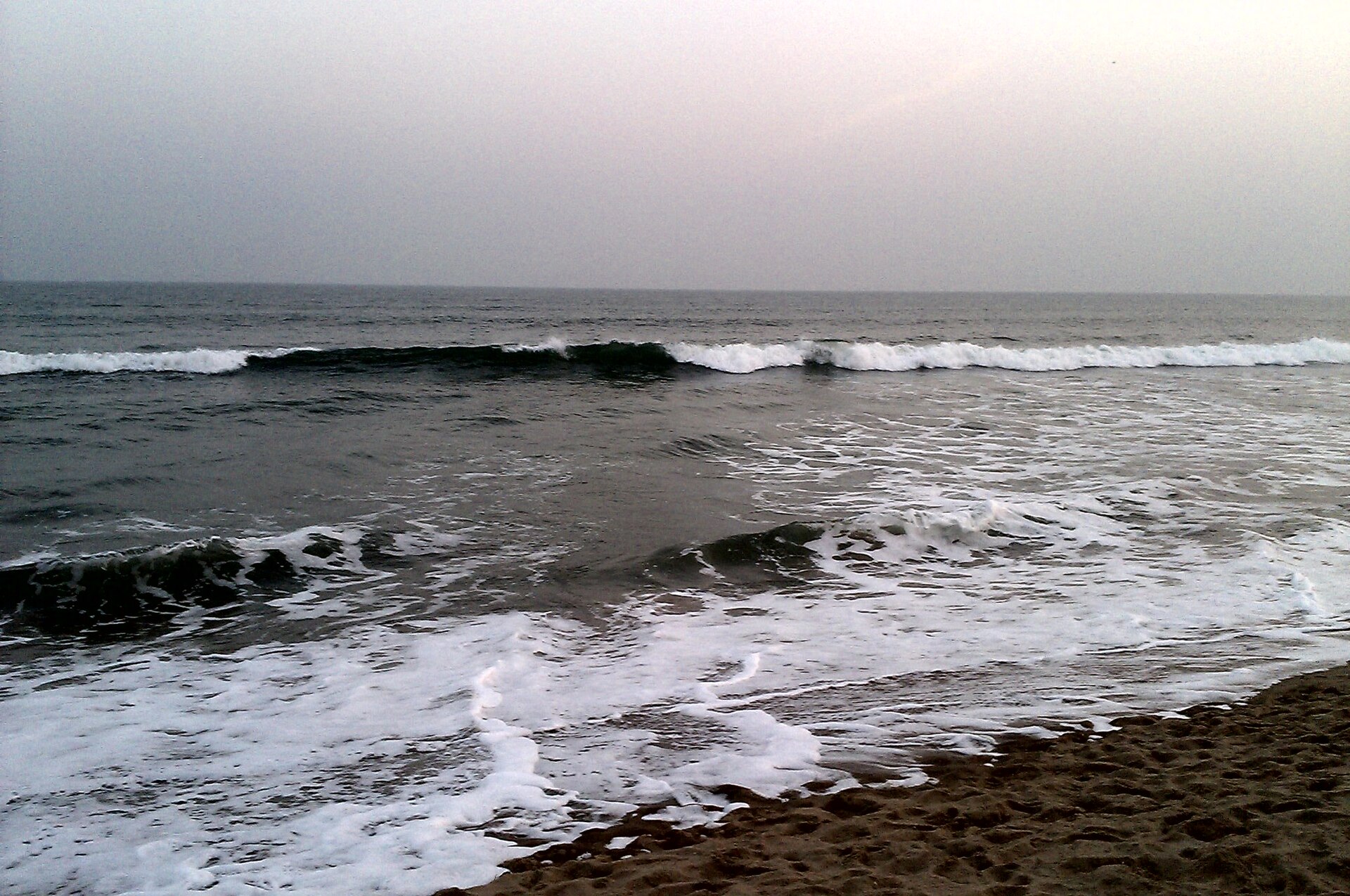 Vast golden sandy beach, rolling Bay of Bengal waves, and historic seaside structures at Gopalpur-on-Sea in Ganjam Odisha
