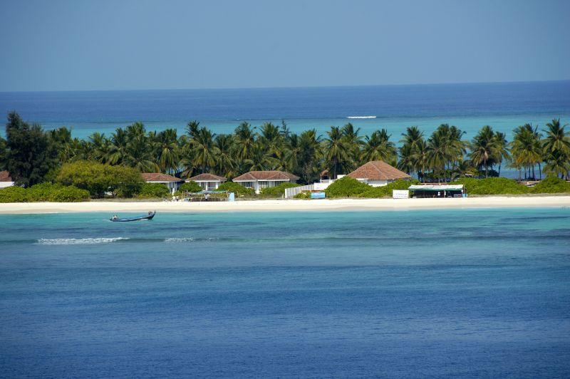 Pristine white coral sands, swaying coconut palm trees, and turquoise lagoon waters at Kadmat Beach Resort in Lakshadweep
