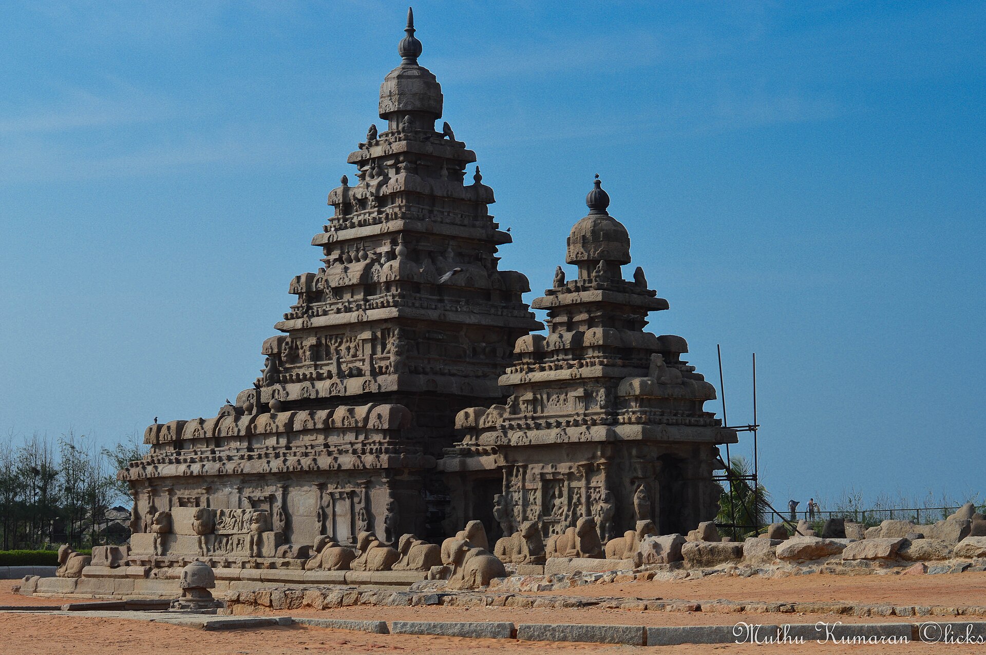 8th century granite Shore Temple standing on the rocky foreshore facing breaking Bay of Bengal surf at Mahabalipuram in Tamil Nadu