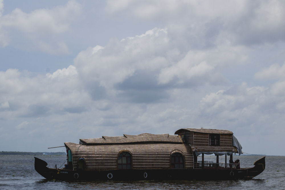 Ashtamudi Lake backwaters in Kollam Kerala lined with palms and houseboats