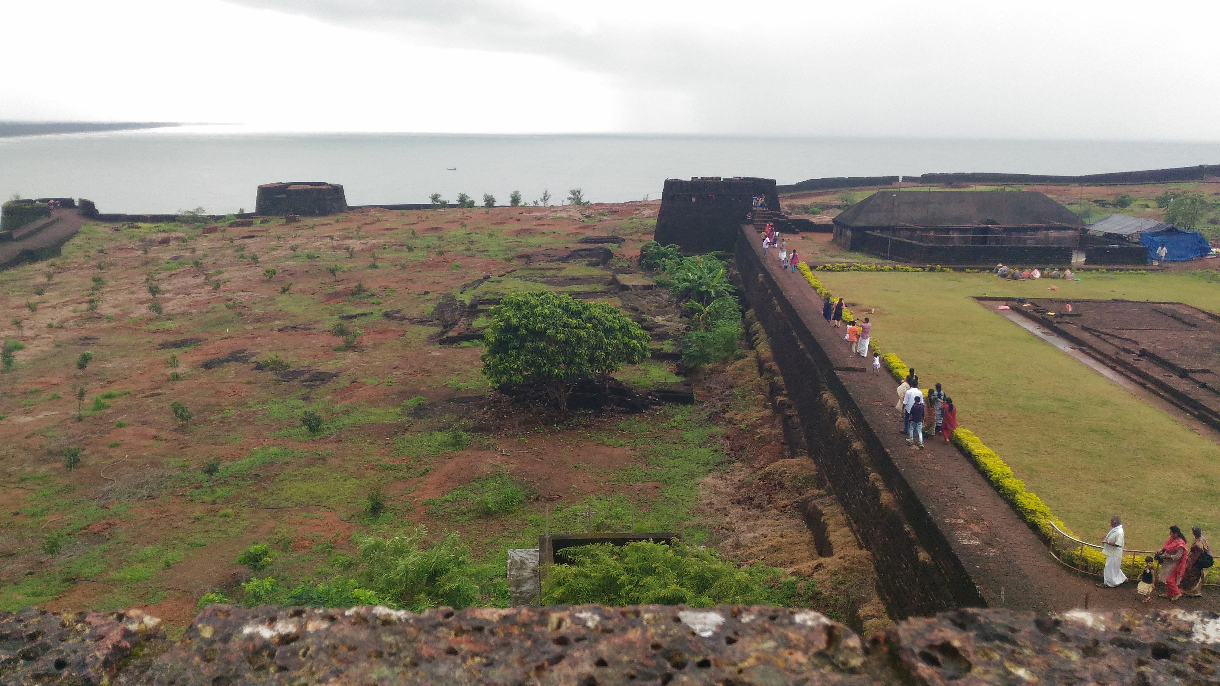 View of the red laterite stone walls and observation tower of Bekal Fort overlooking the Arabian Sea in Kasaragod, Kerala