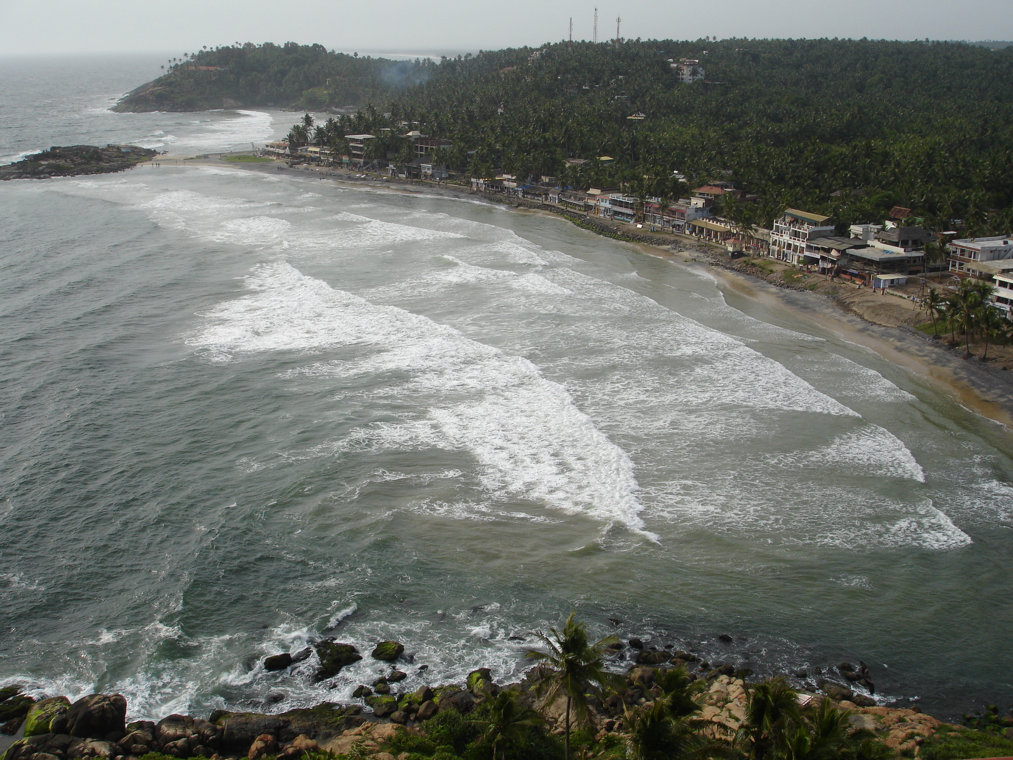 144-foot red and white 1902 Tangasseri Lighthouse and golden sands of Kollam Beach in Kerala
